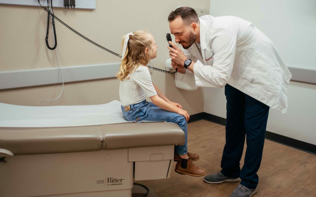 Pediatric patient being examined for concussion by an AFC healthcare provider in an examination room after a fall on the playground.